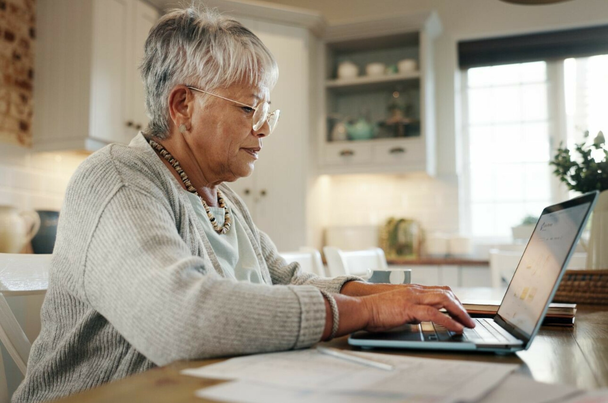 Consumer nz website promo image  a woman reviews her retirement plan on a computer in her home