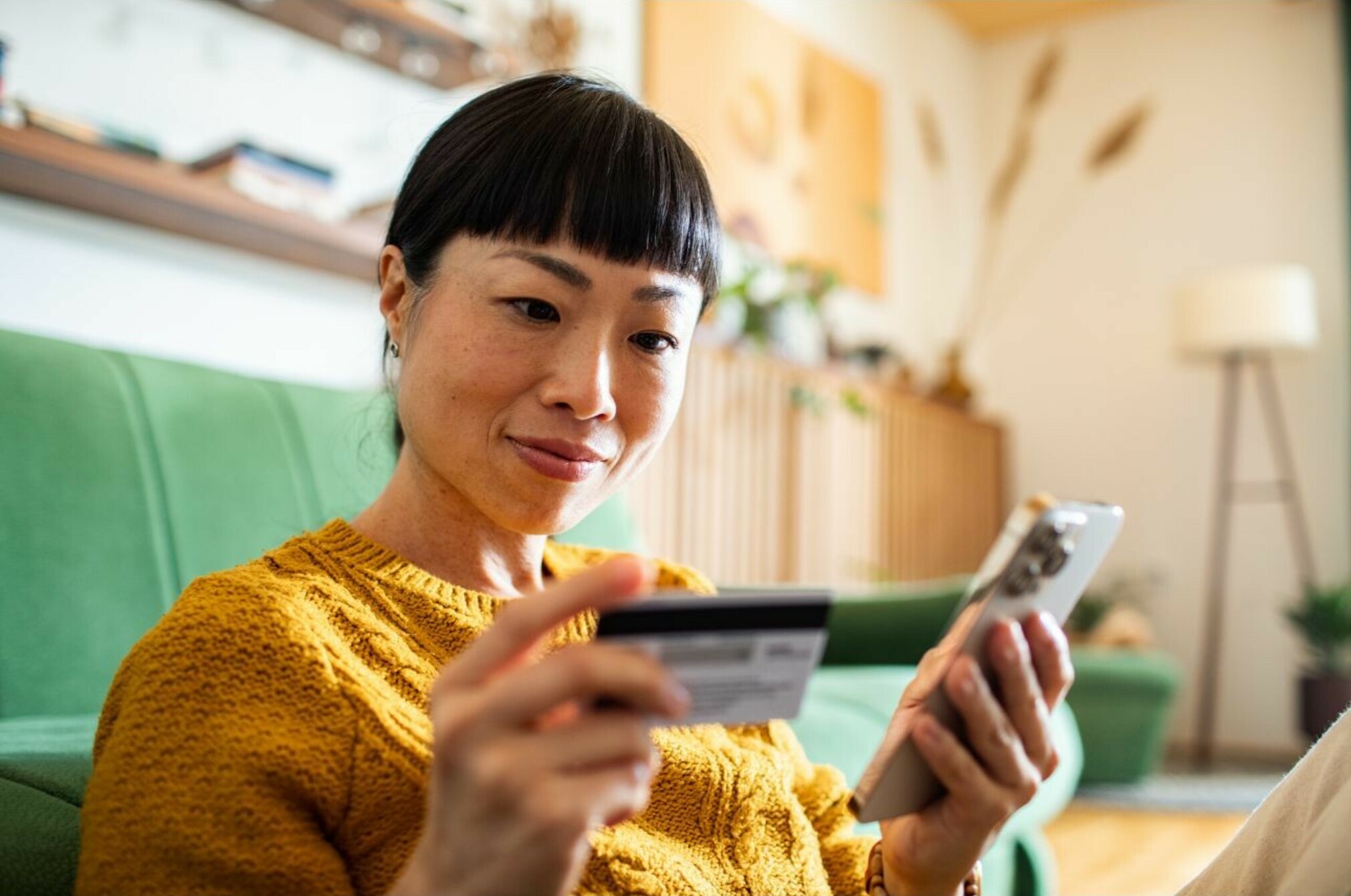 Consumer nz website promo image a woman receives her new credit card and does some banking admin on her phone