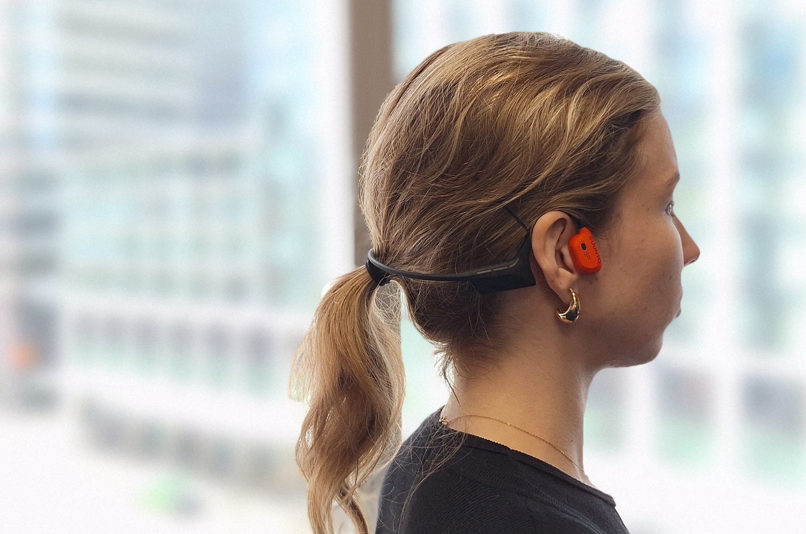 Woman wearing Suunto Wing 2 headphones.