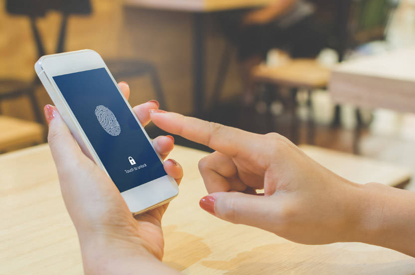 Woman unlocking phone with fingerprints.