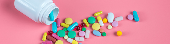 Pills spilling out of white bottle. 