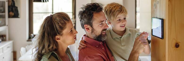 Photo of a family looking at a thermostat