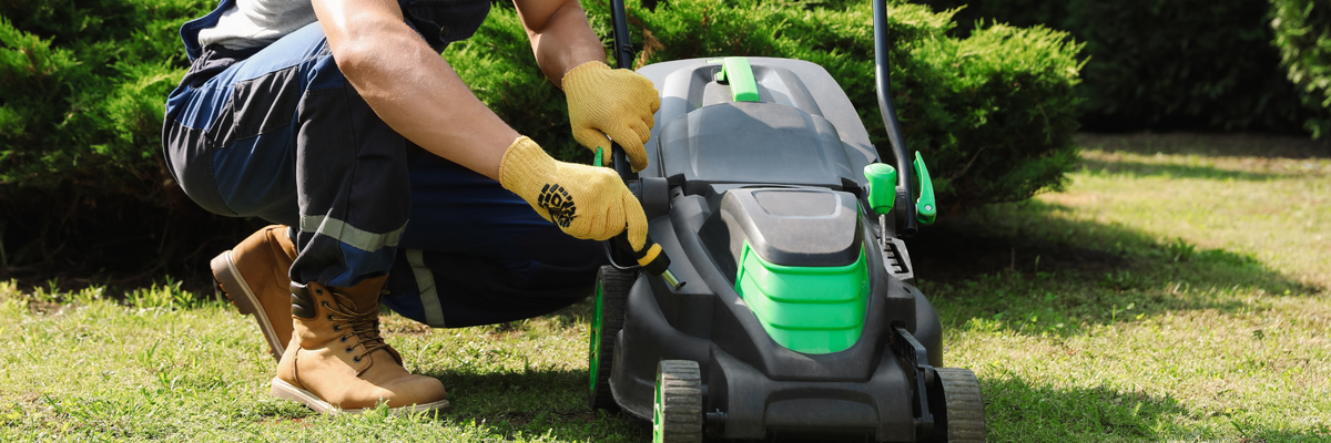 Man doing maintenance on a lawn mower.