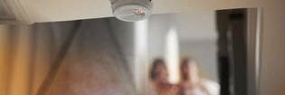 Smoke alarm with couple in background