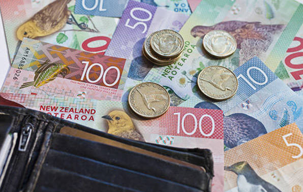 New Zealand cash and coins beside a black wallet.